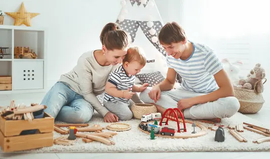 kinderzimmer-kinder-familie-zimmer-spielen-09 Mutter und Vater spielen zusammen mit ihrem Kind im Kinderzimmer